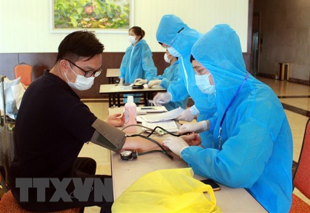 Giving health checkups to foreign experts and workers before quarantine (Photo: VNA)