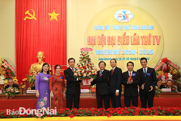Các đồng chí trong Ban TVTU và đại diện các Ban Đảng Tỉnh ủy tặng hoa đồng chí Nguyễn Văn Nải, nguyên Bí thư Thành ủy Long Khánh hoàn thành nhiệm vụ tại đại hội.