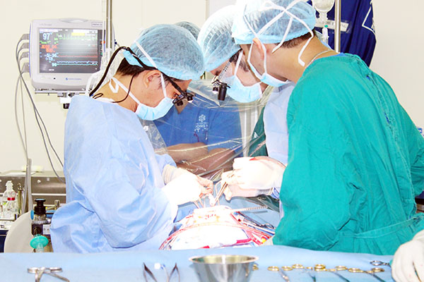 TS-BS Nguyễn Anh Dũng (bìa trái) cùng ê kíp bác sĩ thực hiện một ca phẫu thuật tim cho bệnh nhi tại Bệnh viện Đa khoa Đồng Nai. Ảnh: H.DUNG        