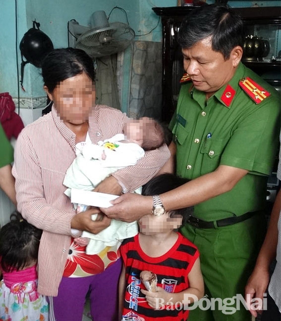 Thượng tá Phan Trọng Lộc, Trưởng Công an H.Xuân Lộc trao tiền hỗ trợ gia đình chị L.T.T. (ngụ xã Xuân Hiệp, H.Xuân Lộc) để vượt qua khó khăn. Ảnh: Quang Hảo