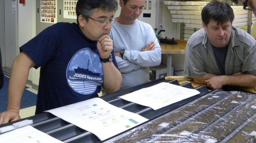 Researchers Yuki Morono, Laurent Toffin and Steven DÕHondt (L-R) work aboard the research drillship JOIDES Resolution with sediment cores gathered from deep beneath the seafloor under the Pacific Ocean in this undated photograph released on July 28, 2020.