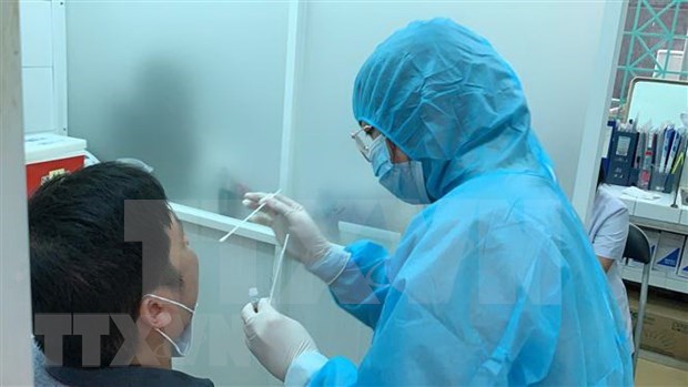 A medical worker takes sample for COVID-19 testing from a man in Vietnam. (Photo: VNA)