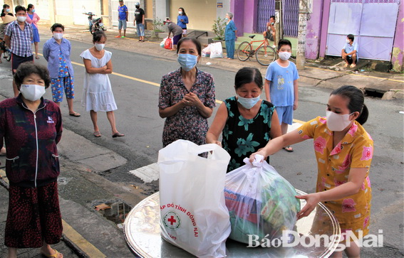 Các hộ dân tại khu vực phong tỏa đường Hồ Văn Đại, phường Quang Vinh, TP.Biên Hòa nhận quà