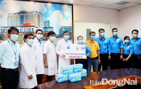 Đại diện Hội Liên hiệp Thanh niên Việt Nam tỉnh tặng bảng tượng trưng 10 ngàn khẩu trang y tế cho lãnh đạo Bệnh viện Đa khoa Đồng Nai.
