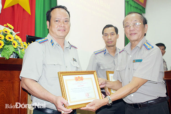 Cục trưởng Thi hành án dân sự tỉnh Phan Văn Châu (bìa phải) tặng giấy khen cho các cá nhân có thành tích xuất sắc trong đợt thi đua cao điểm thi hành án đợt 1-2020 (từ tháng 4 đến tháng 6). Ảnh: Đ.Phú