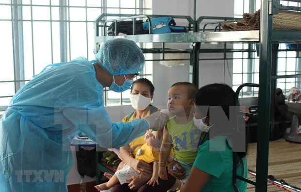 A doctor in a qurantine facility in Khanh Hoa is giving health check-up to people who are under quarantine (Photo: VNA)