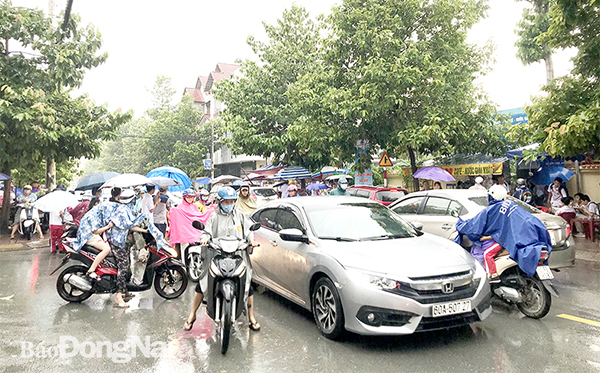 Các phương tiện di chuyển khó khăn khi đi qua khu vực trước cổng Trường song ngữ Lạc Hồng (P.Bửu Long, TP.Biên Hòa) vào giờ tan học. Ảnh: K.Liễu