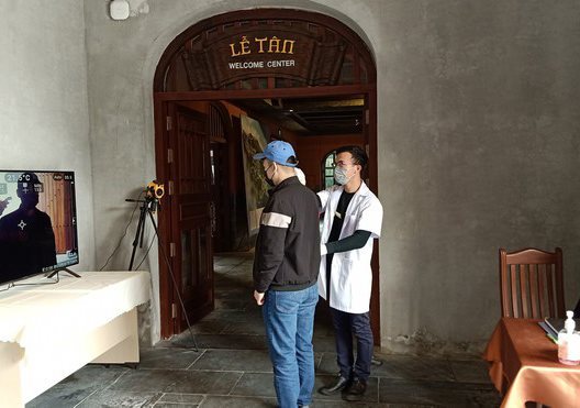 A health worker checks the temperature of a visitor at a tourist attraction – PHOTO: VGP