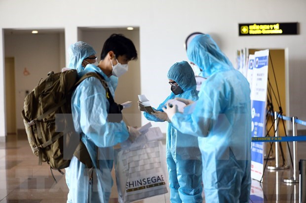 Vietnamese officials check COVID-19 test results of passengers at an airport. (Photo: VNA)