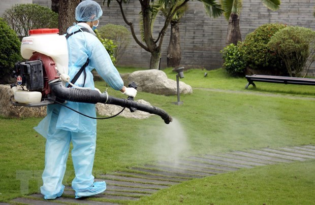 A health worker sprays disinfectant to prevent the spread of COVID-19 (Photo: VNA)