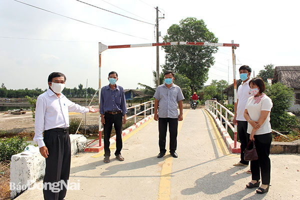 Bí thư Chi bộ Trịnh Văn Mười (bìa trái) giới thiệu cây cầu bê tông mới tại hẻm 5, tổ nhân dân 28 vừa được xây dựng - công trình chào mừng 90 năm Ngày truyền thống công tác Dân vận của Đảng (15-10). Ảnh: N.Hà