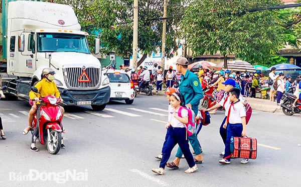 Dân quân thường trực P.Bửu Hòa (TP.Biên Hòa) giúp các học sinh qua đường Bùi Hữu Nghĩa khi tan học 