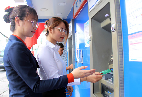 Nhân viên Sacombank chi nhánh Đồng Nai hướng dẫn khách hàng thực hiện các biện pháp bảo mật tài khoản khi tiến hành giao dịch thẻ trên máy ATM. Ảnh: Hải Quân