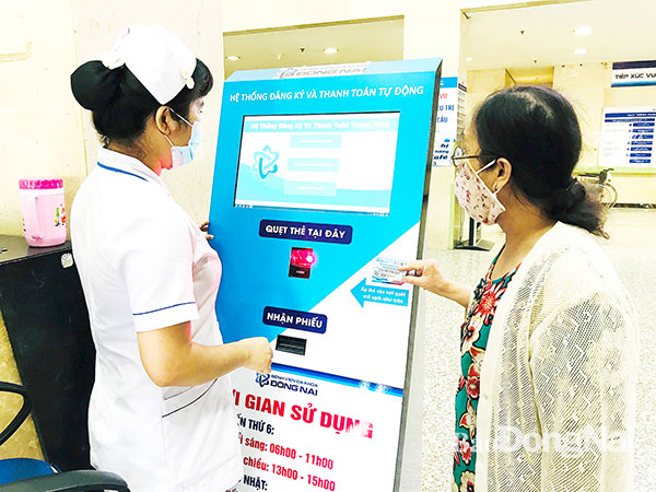 Nhân viên Bệnh viện Đa khoa Đồng Nai hướng dẫn bệnh nhân đăng ký khám bệnh bằng thẻ khám bệnh One Card. 