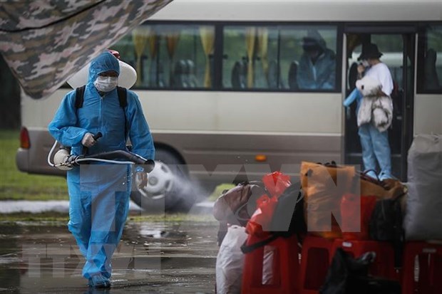 Spraying disinfectant on luggage of quarantined people (Photo: VNA)