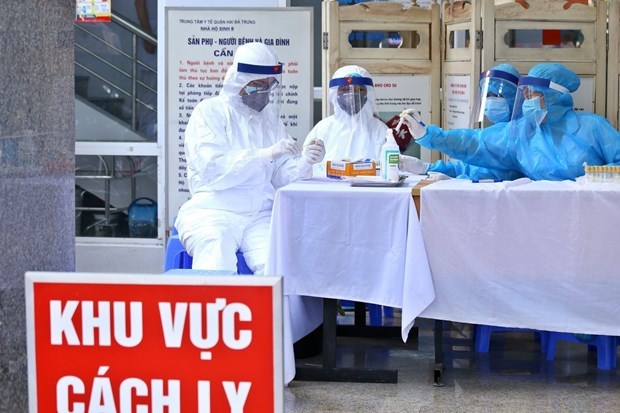 Health workers at a hospital in Hanoi collect specimens for COVID-19 testing.