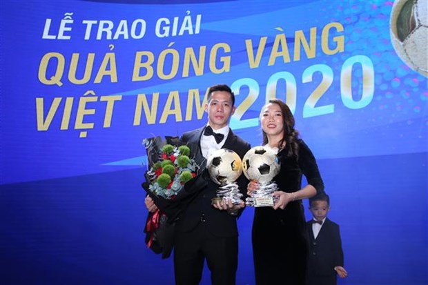 Forward and captain Nguyen Van Quyet (L) of Hanoi FC and striker Cu Thi Huynh Nhu of HCM City Club win the Golden Ball awards for player of the year (Photo: VNA)