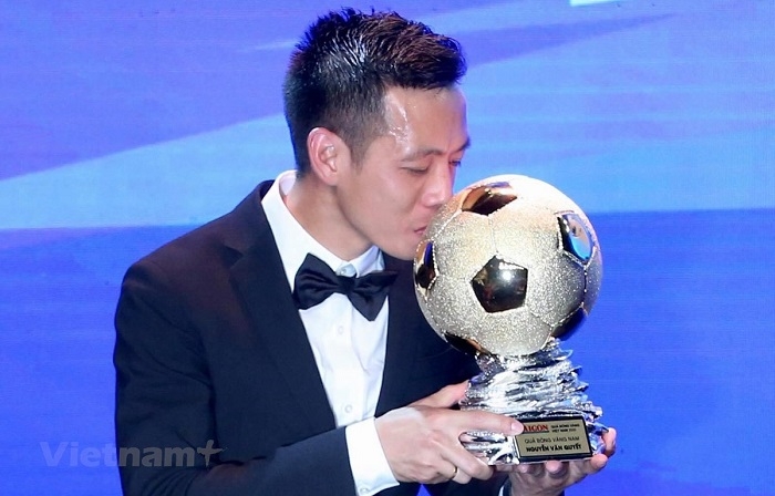 Hanoi FC forward Nguyen Van Quyet kisses the Golden Ball trophy after receiving the award on January 12. (Photo: VN+)