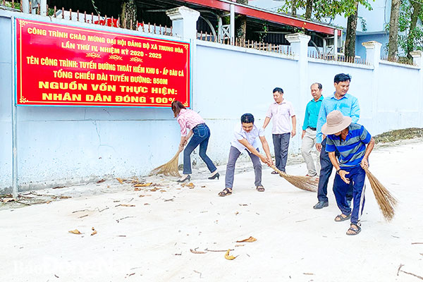 Cán bộ và người dân ấp Bàu Cá, xã Trung Hòa (H.Trảng Bom) cùng quét dọn một tuyến đường mới được làm từ nguồn xã hội hóa. Ảnh: C.T.V