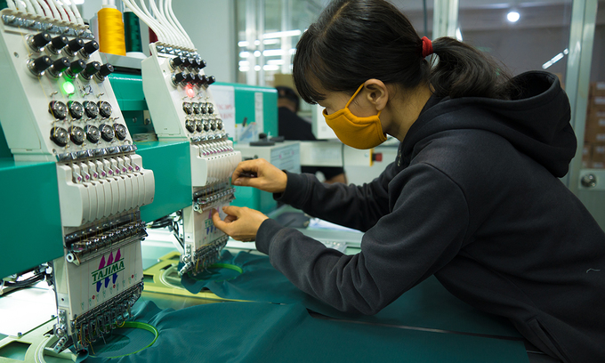 A female employee checks embroidery machines in a textile factory in Ba Ria-Vung Tau Province, southern Vietnam in January 2021. Photo by Shutterstock/Dong Nhat Huy.