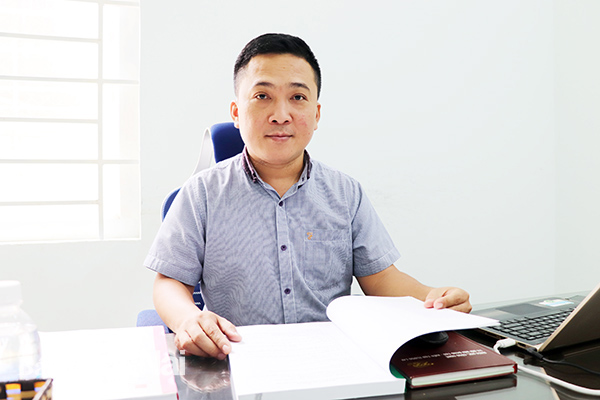 Ông Nguyễn Công Khánh, Phó chi cục trưởng Chi cục Tiêu chuẩn - đo lường - chất lượng Đồng Nai xem một bộ hồ sơ của doanh nghiệp tham gia Giải thưởng chất lượng quốc gia