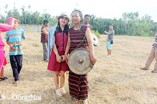 Bà Thị Thành chụp hình cùng sinh viên Trường đại học Văn hóa TP.HCM trong buổi giao lưu cồng chiêng Chơro ở ấp Lác Chiếu (xã Bảo Quang, TP.Long Khánh). Ảnh: L.Na