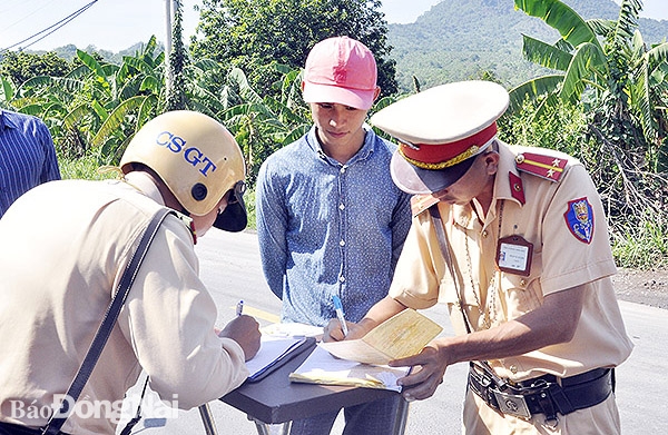 Lực lượng chức năng lập biên bản người điều khiển phương tiện vi phạm chở hàng quá tải trên địa bàn H.Thống Nhất. Ảnh: T.hHải