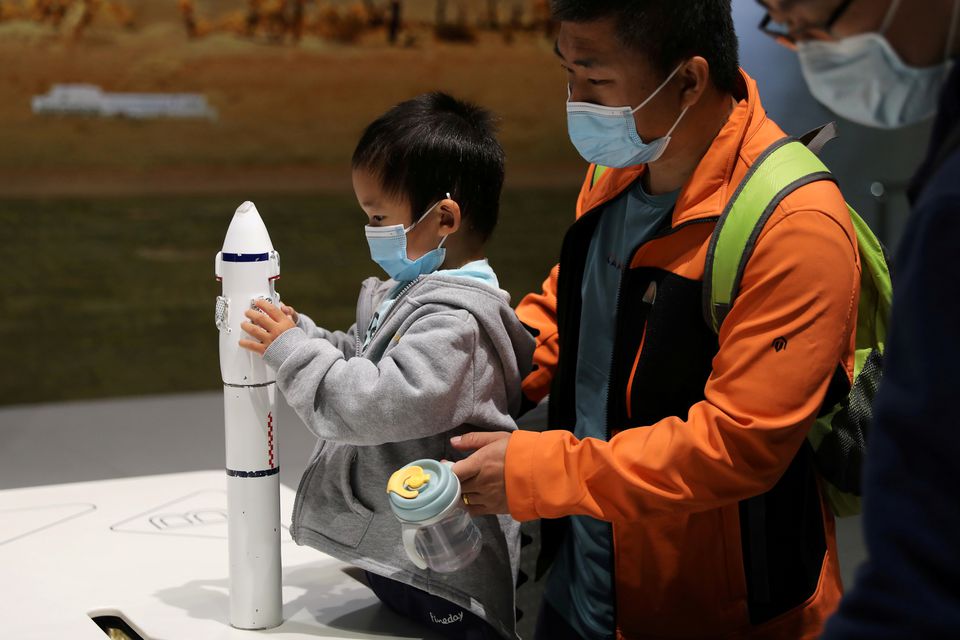 A child holds part of a rocket model at an exhibition featuring the development of China's space exploration on the country's Space Day at China Science and Technology Museum in Beijing, China April 24, 2021.