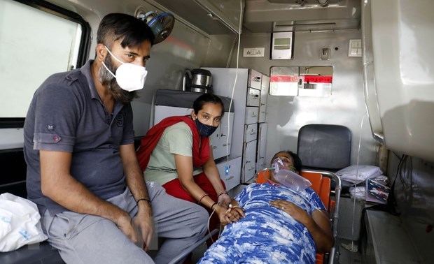 A COVID-19 patient being treated in an ambulance to wait for a bed in hospital.