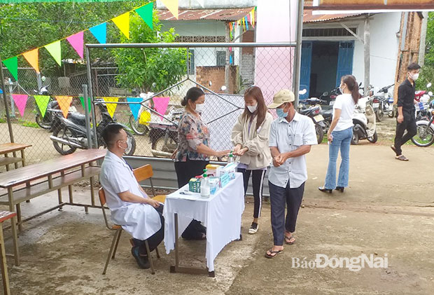 Đồng bào dân tộc Mường ở điểm bầu cử số 7, xã Phú Túc, H.Định Quán rửa tay sát khuẩn trước khi vào bầu cử