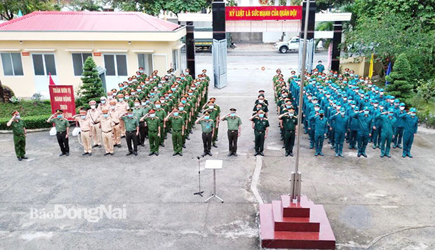 Đông đảo cử tri là cán bộ chiến sỹ lực lượng vũ trang tham dự lễ chào cờ để chuẩn bị bầu cử tại khu vực bỏ phiếu số 3, đơn vị bầu cử số 2, tại Trụ sở Quân sự huyện Nhơn Trạch
