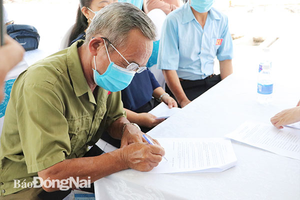 Một hộ dân ký nhận quyết định bàn giao đất tại khu tái định cư Lộc An - Bình Sơn (H.Long Thành). Ảnh: P.Tùng