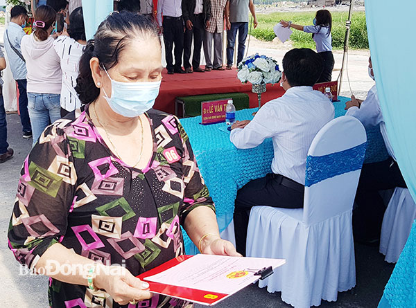 Một hộ dân nhận quyết định bàn giao đất và giấy chứng nhận quyền sử dụng đất tại khu tái định cư Lộc An - Bình Sơn. Ảnh: P.Tùng