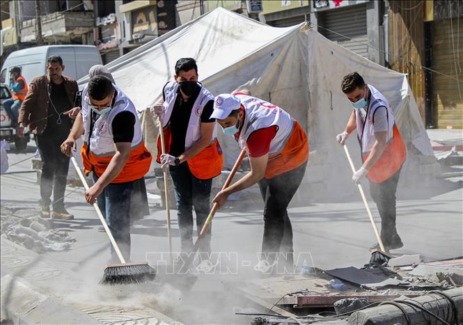 Các tình nguyện viên dọn dẹp đống đổ nát của các tòa nhà bị sập sau loạt không kích của Israel xuống Dải Gaza, ngày 23/5/2021. Ảnh: THX/TTXVN
