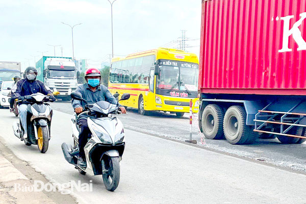 Do dây cảnh báo giữa đường dành cho xe máy và xe ô trên quốc lộ 51 (đoạn đang thi công gần khu vực ngã ba Bến Gỗ) bị đứt nên các phương tiện lưu thông lẫn lộn rất dễ xảy ra va chạm giao thông. Ảnh: Đông Hồ