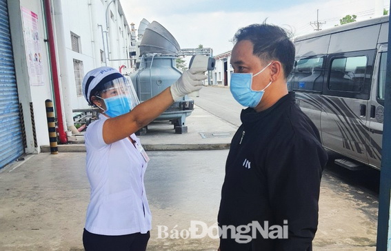 Công ty TNHH Công nghiệp Plus Việt Nam (KCN Biên Hòa 2, TP.Biên Hòa) đo thân nhiệt cho người lao động trước khi vào công ty.