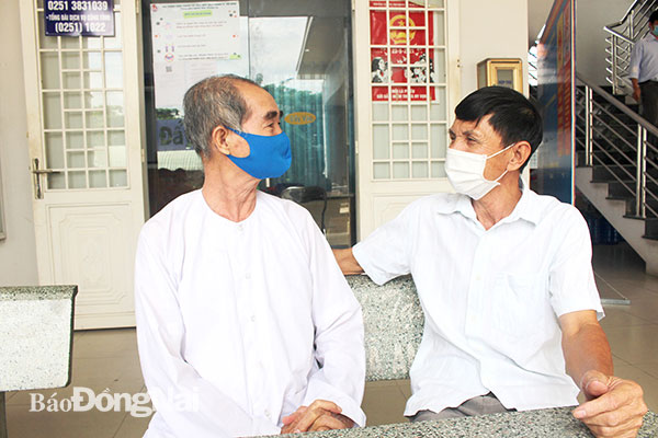 Ông Phạm Hùng Biện (bên phải) trao đổi với người dân về việc ủng hộ phòng, chống dịch Covid -19. Ảnh: Nguyệt Hà