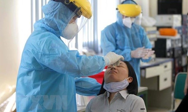 A medical worker takes sample for COVID-19 testing. (Photo: VNA)