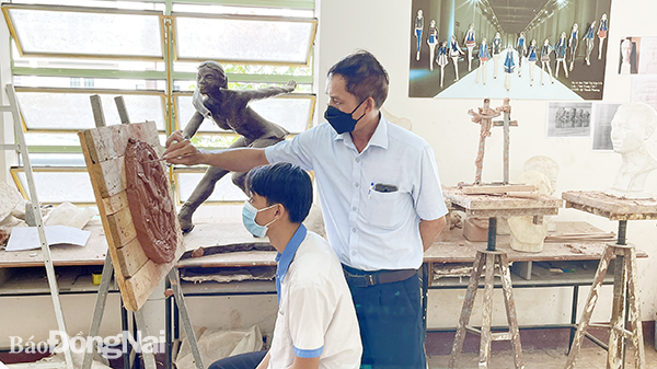 ThS Nguyễn Trường Giang, Phụ trách Khoa Gốm, Trường cao đẳng Mỹ thuật trang trí Đồng Nai hướng dẫn sinh viên Nguyễn Hữu Nghĩa thực hành gốm trong thời dịch Covid-19. Ảnh: M.Ny