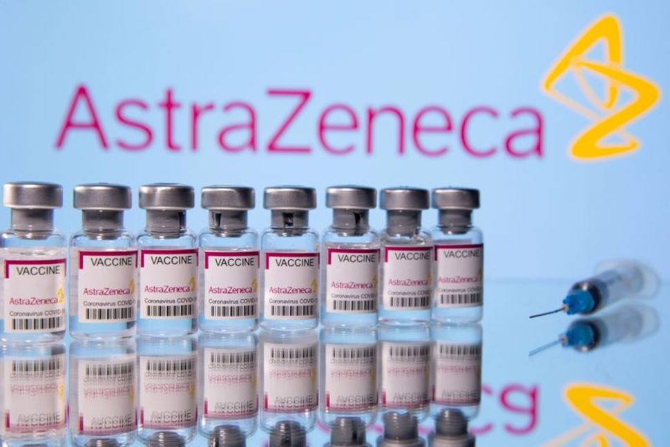 FILE PHOTO: Vials labelled "Astra Zeneca COVID-19 Coronavirus Vaccine" and a syringe are seen in front of a displayed AstraZeneca logo, in this illustration photo taken March 14, 2021. 