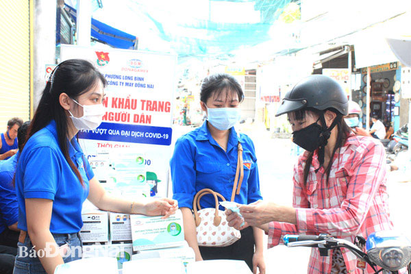 Đoàn P.Long Bình và Đoàn cơ sở Công ty CP Tổng công ty May Đồng Nai vừa bán khẩu trang trợ giá, vừa tuyên truyền để người dân nghiêm chỉnh chấp hành việc đeo khẩu trang. Ảnh: Nga Sơn