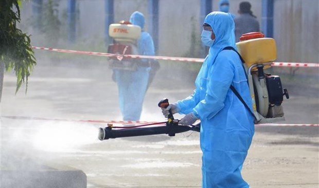 Medical workers spray disinfectant.