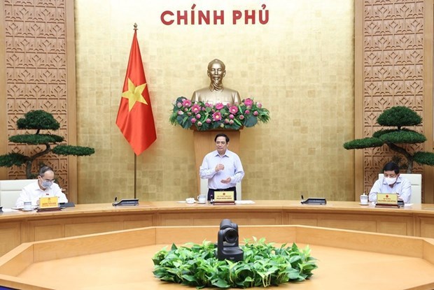 Prime Minister Pham Minh Chinh at a working session with leaders of ministries, vaccine producers and scientists in Hanoi on July 23.