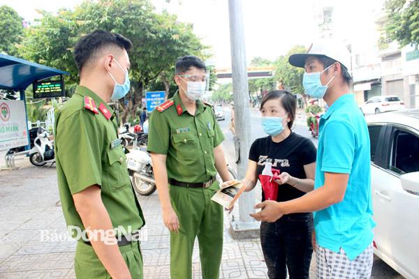 Là lực lượng tuyến đầu chống dịch, thường xuyên tiếp xúc với nhiều người khi làm nhiệm vụ, các cán bộ - chiến sĩ luôn đối diện với nguy cơ lây nhiễm Covid-19 cao. Trong ảnh: Tổ tuần tra Công an TP.Biên Hòa kiểm tra nhắc nhở người dân thực hiện các quy định về giãn cách xã hội. Ảnh: Trần Danh