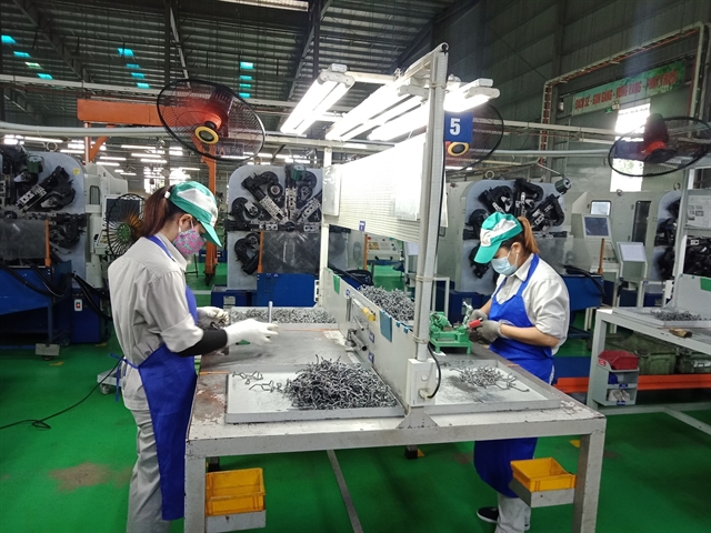 Workers of the Đông Anh Chain and Free-Wheel Co Ltd ensure COVID-19 preventive measures while working. — VNA/VNS Photo Minh Nghĩa