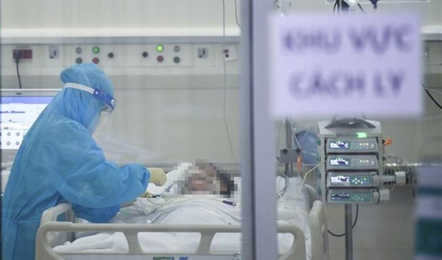 A nurse examines a critically-ill COVID-19 patient at an ICU in HCM City. 