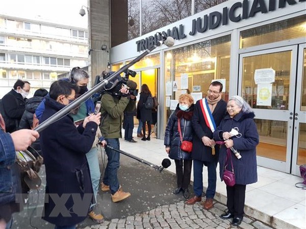 Tran To Nga (R) takes a photo with her supporters before a hearing for her lawsuit in France.