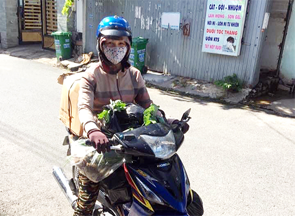 Thành viên các tổ phụ nữ ở P.Long Bình Tân (TP.Biên Hòa) vận chuyển, giao các đơn hàng thực phẩm bình ổn giá đến người dân ở các tổ dân phố trên địa bàn. Ảnh: Hội LHPN P.Long Bình Tân cung cấp