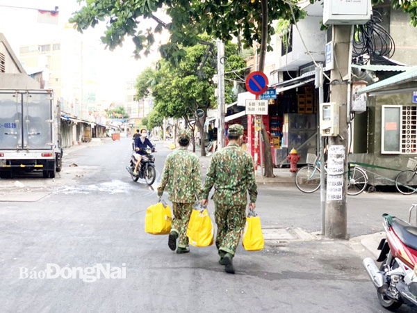 Hình ảnh những anh bộ đội với những túi hàng đang đi trao cho người dân khiến nhiều người xúc động (Nguồn: Báo Tin tức)