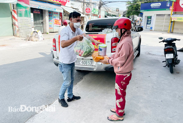 Anh Nguyễn Thiên Báo trực tiếp đến khu vực bị phong tỏa, cách ly y tế ở P.Trảng Dài (TP.Biên Hòa) trao tặng nhu yếu phẩm cho người dân có hoàn cảnh khó khăn. Ảnh: Tố Tâm